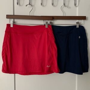 Set of two women’s golf skorts. Size M one pink, one Navy